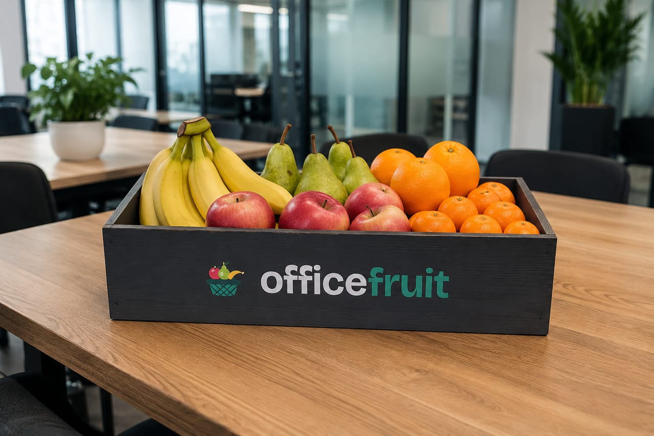 OfficeFruit gyümölcsláda friss almával, banánnal, körtével és naranccsal egy irodai tárgyalóasztalon